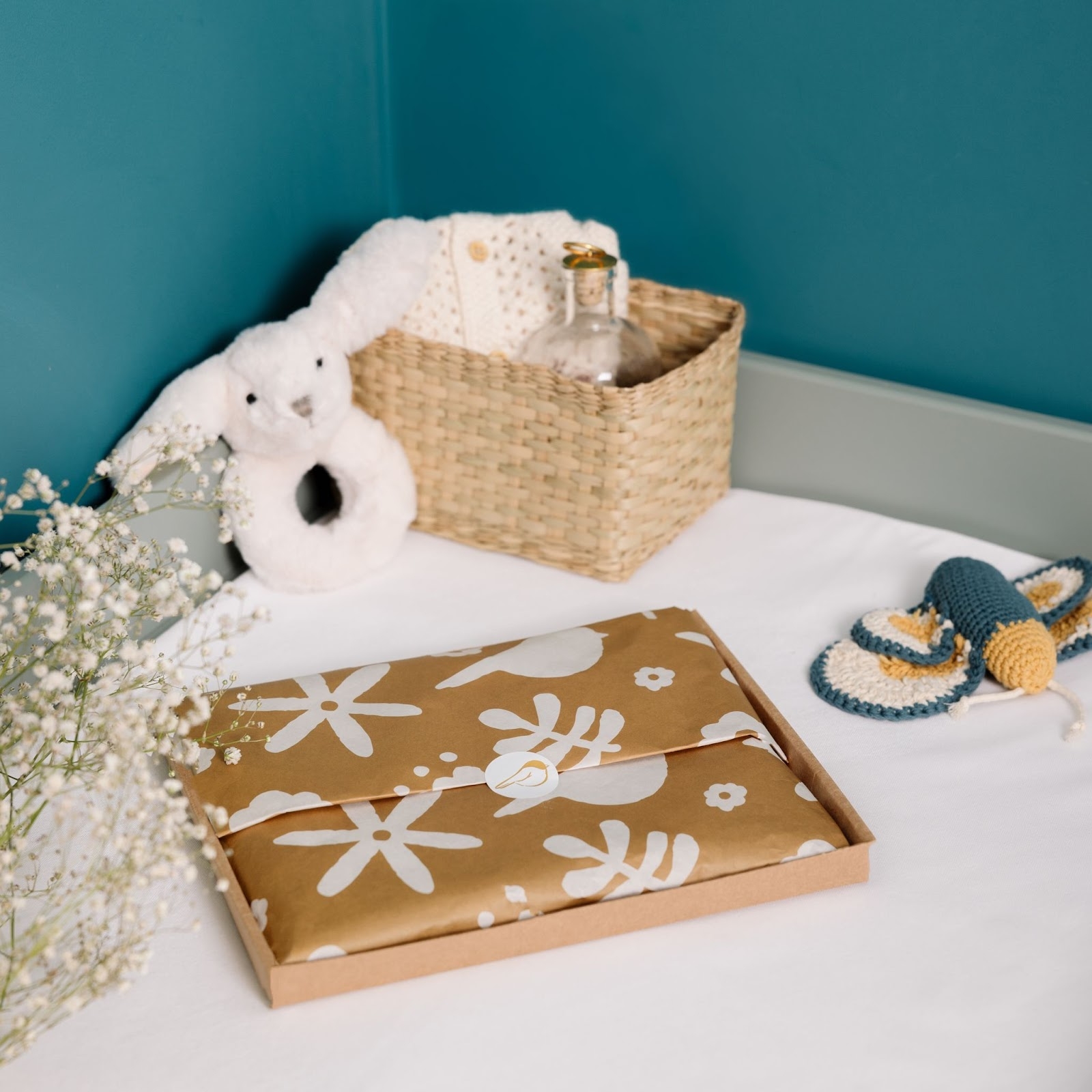 Photo d’un coffret cadeau de naissance Les Nonnettes posé sur un lit